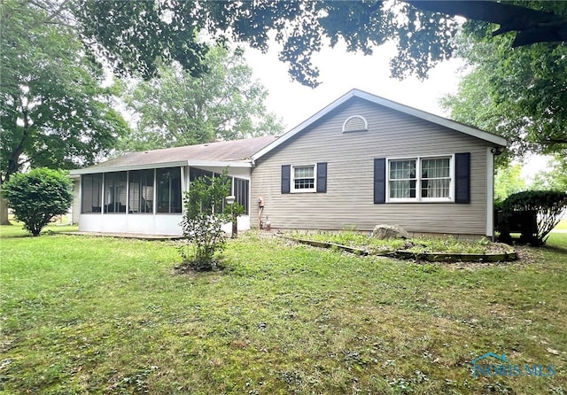 view of front facade featuring a sunroom and a front yard