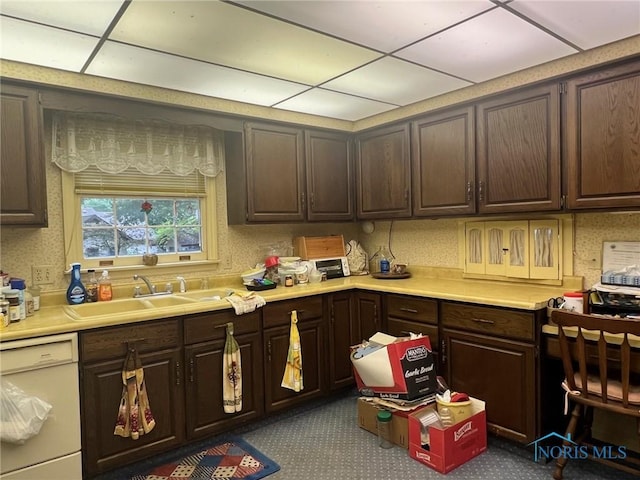 kitchen featuring a drop ceiling, sink, dark brown cabinets, and dishwasher