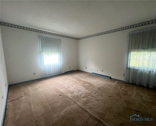 empty room with carpet and a baseboard heating unit