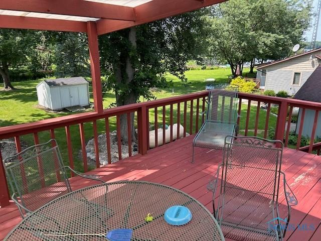 deck featuring a shed and a yard