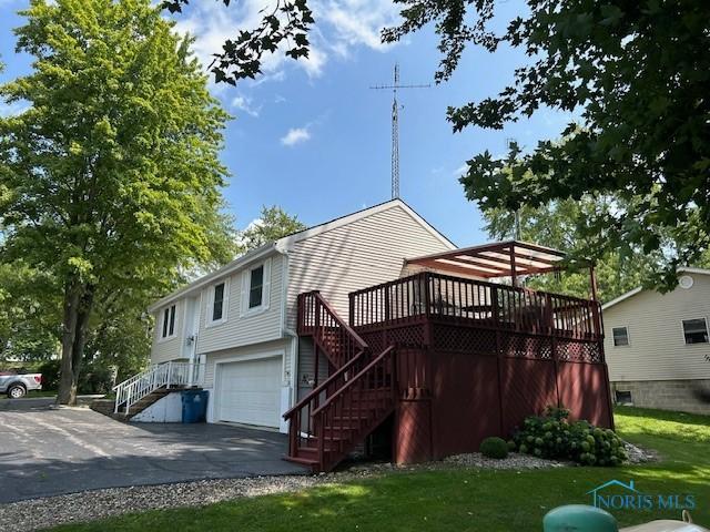 view of side of home featuring a wooden deck and a garage