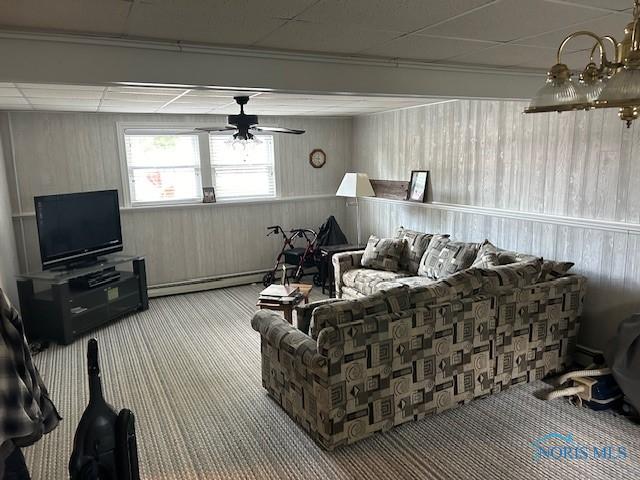 living room featuring a drop ceiling, carpet, ceiling fan, and baseboard heating