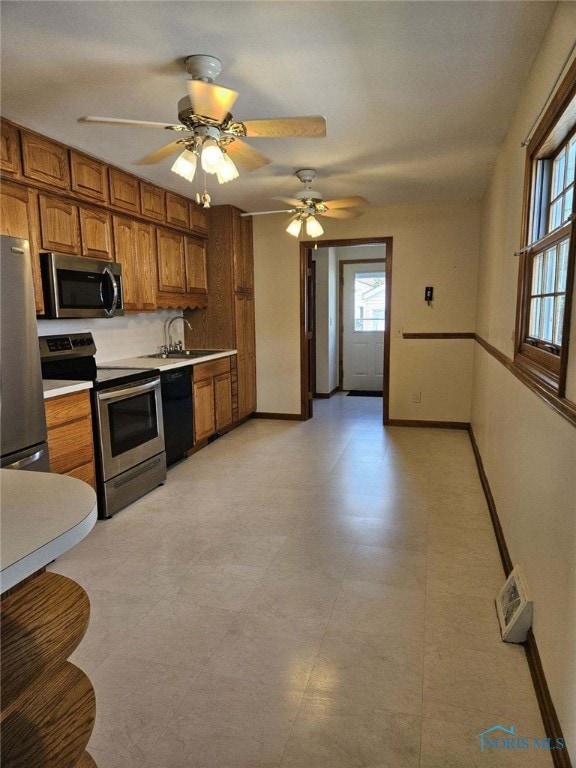 kitchen with ceiling fan, sink, and stainless steel appliances