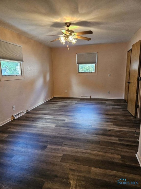 spare room featuring ceiling fan and dark hardwood / wood-style floors