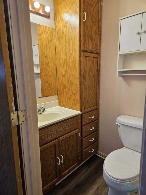 bathroom featuring vanity, wood-type flooring, and toilet