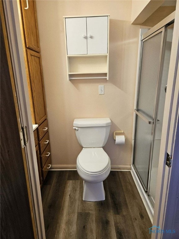 bathroom with hardwood / wood-style flooring, toilet, and walk in shower