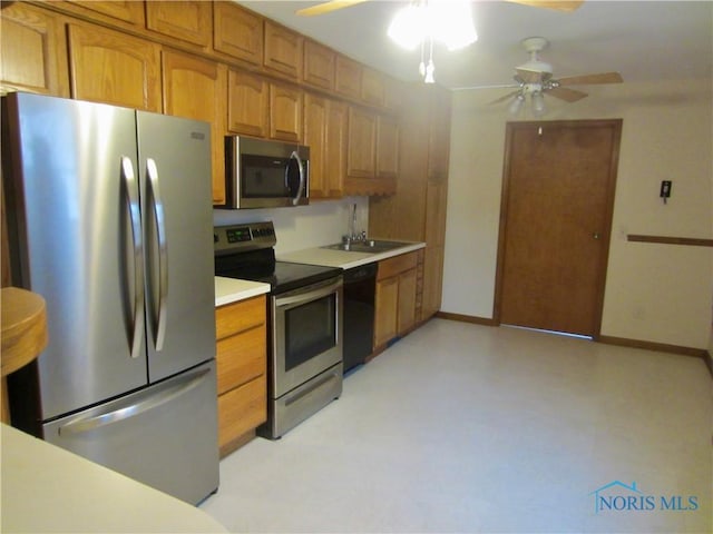 kitchen with appliances with stainless steel finishes, ceiling fan, and sink