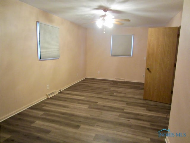 spare room featuring dark hardwood / wood-style floors and ceiling fan