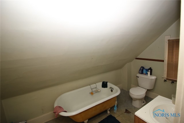 bathroom with vanity, vaulted ceiling, a bathtub, toilet, and tile patterned flooring