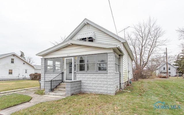 bungalow with a sunroom and a front yard