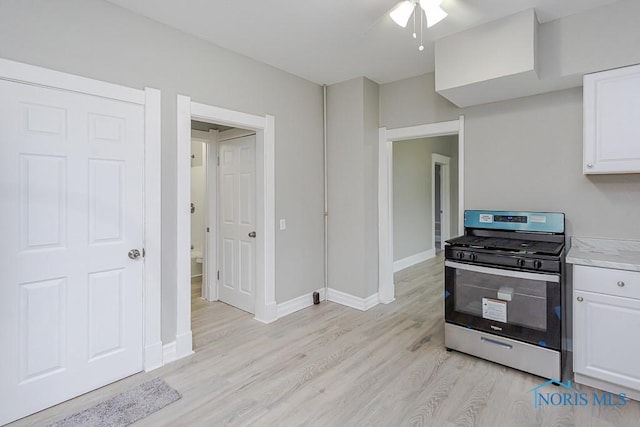 kitchen featuring ceiling fan, white cabinets, light hardwood / wood-style floors, and stainless steel gas range