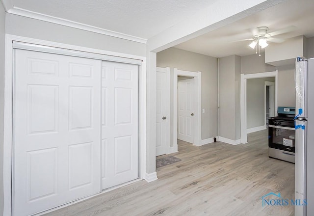 interior space featuring a closet, light hardwood / wood-style flooring, ceiling fan, and white fridge