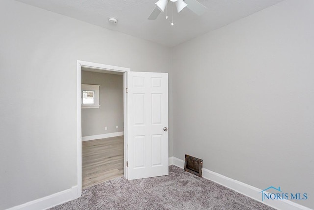 carpeted empty room featuring ceiling fan