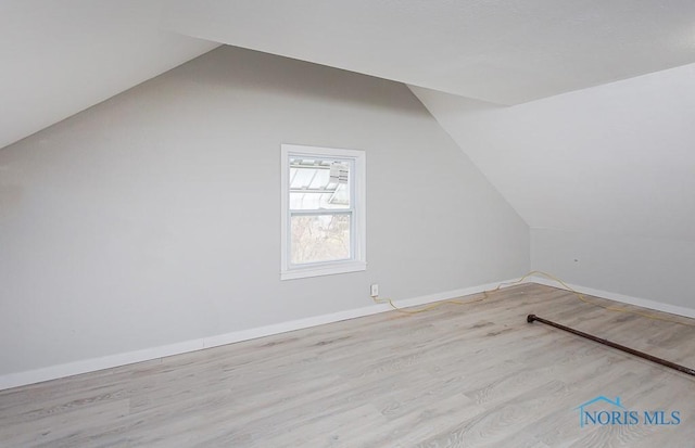 additional living space featuring lofted ceiling and light wood-type flooring