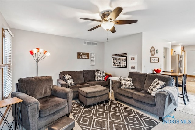 living room featuring ceiling fan and tile patterned floors