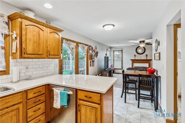 kitchen with kitchen peninsula, backsplash, and ceiling fan