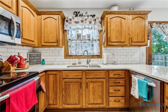 kitchen featuring stainless steel appliances, sink, and decorative backsplash