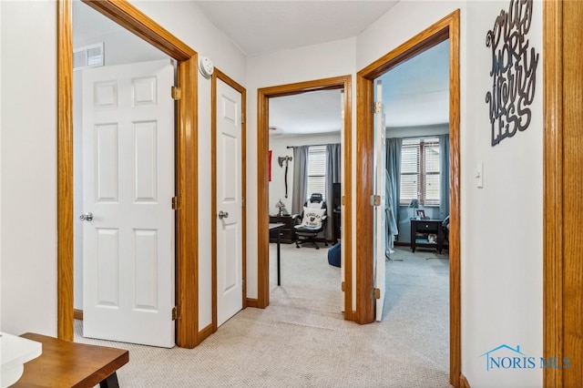 hall with light colored carpet