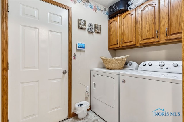 washroom featuring separate washer and dryer and cabinets