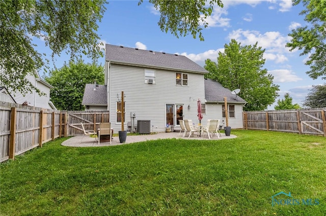 rear view of property featuring a yard, central AC unit, and a patio area