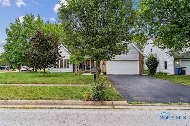 view of property hidden behind natural elements with a garage and a front lawn