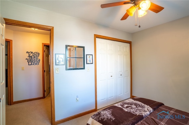 carpeted bedroom featuring a closet and ceiling fan