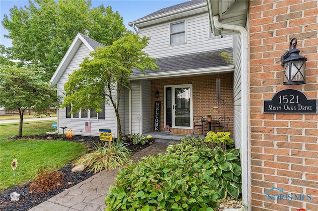 view of exterior entry featuring a yard