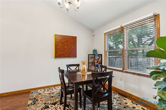 dining area featuring vaulted ceiling, wood-type flooring, and a chandelier