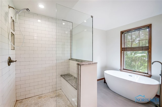 bathroom featuring independent shower and bath and tile walls