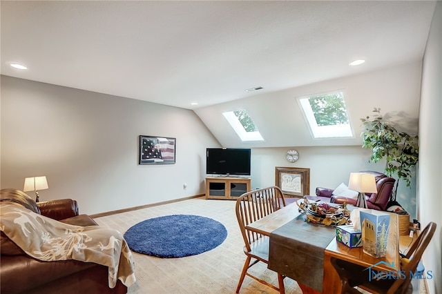 carpeted dining area featuring vaulted ceiling with skylight