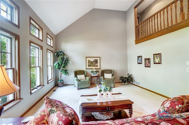 living room with high vaulted ceiling and carpet