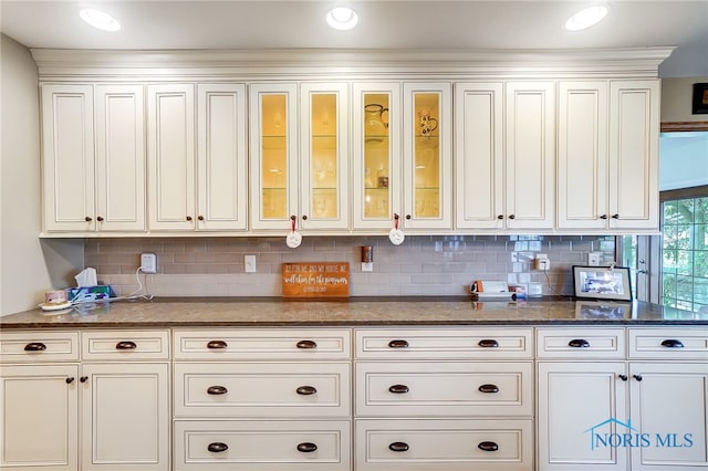 kitchen featuring dark stone counters, tasteful backsplash, and white cabinets