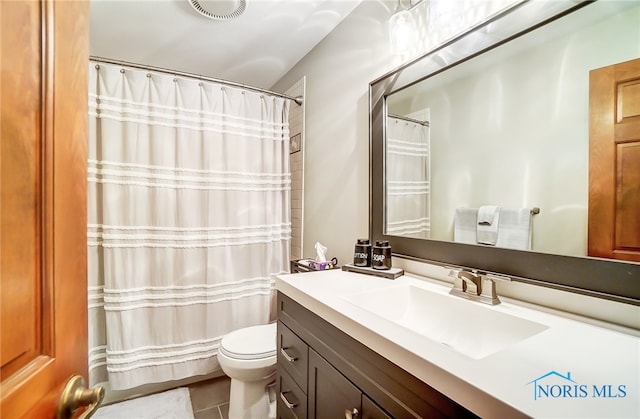 bathroom featuring vanity, tile patterned flooring, and toilet