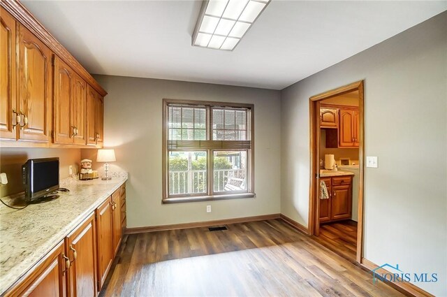 kitchen with light stone counters and hardwood / wood-style floors