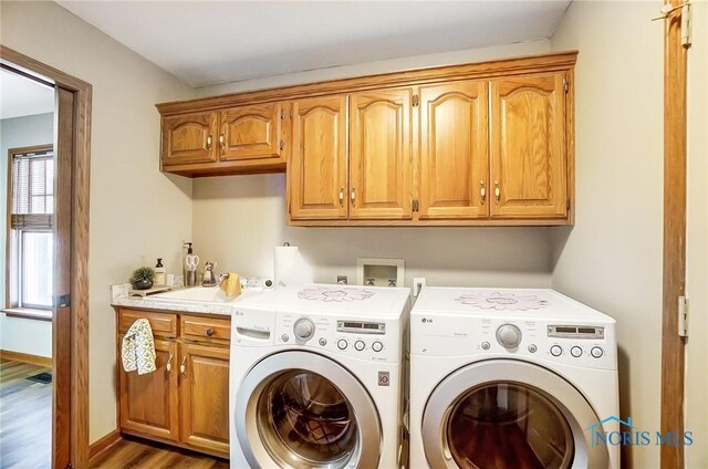 laundry area with washer and clothes dryer, sink, cabinets, and hardwood / wood-style floors