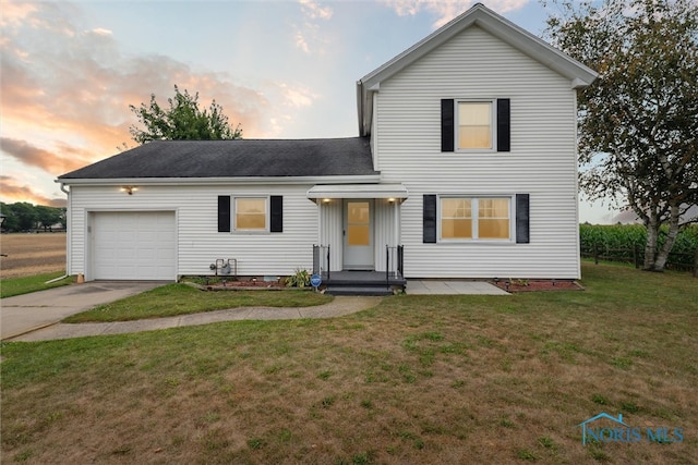 front facade with a garage and a lawn