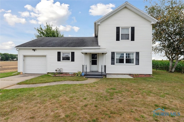 view of property with a garage and a front lawn