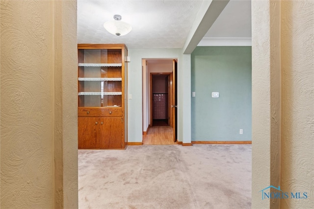 hallway featuring light colored carpet