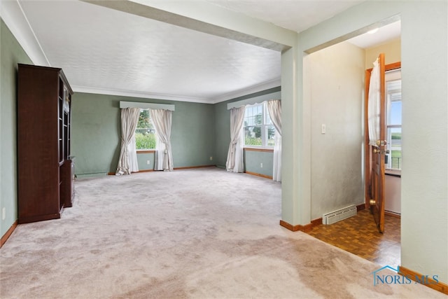 empty room featuring a baseboard radiator, ornamental molding, parquet flooring, and a wealth of natural light