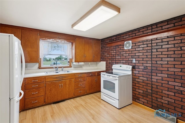 kitchen featuring brick wall, light hardwood / wood-style flooring, white appliances, and sink