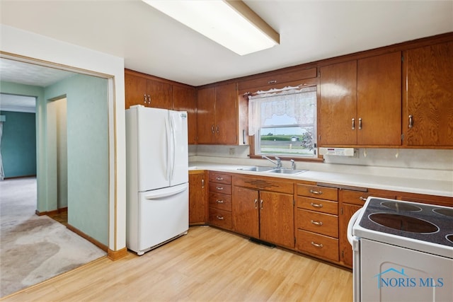 kitchen featuring light carpet, white appliances, and sink