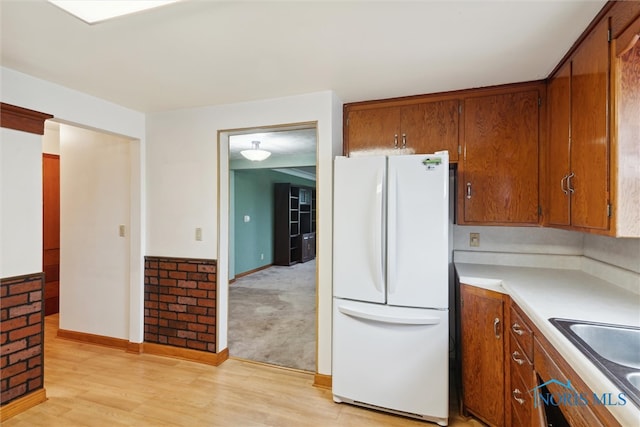 kitchen with light carpet, white fridge, and sink