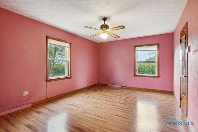 unfurnished room featuring light wood-type flooring, ceiling fan, and a healthy amount of sunlight