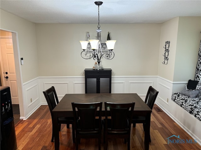 dining area featuring a notable chandelier and dark wood-type flooring