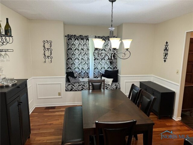 dining area featuring dark hardwood / wood-style floors and a notable chandelier