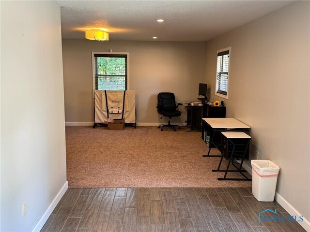 home office featuring plenty of natural light, dark hardwood / wood-style floors, and a textured ceiling