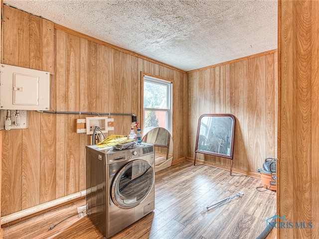 laundry area featuring washer / dryer, wood-type flooring, and wooden walls