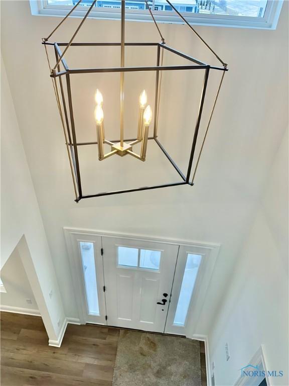 entryway featuring a healthy amount of sunlight, a notable chandelier, baseboards, and wood finished floors