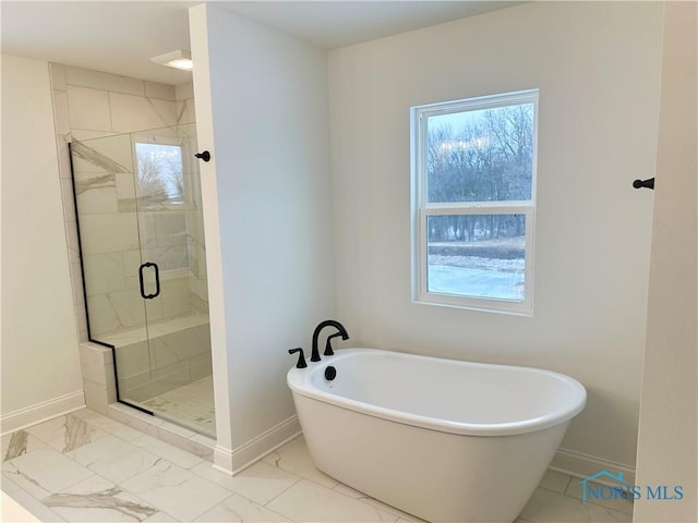 full bath with marble finish floor, a stall shower, a wealth of natural light, and baseboards