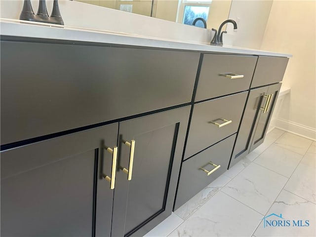 bathroom featuring marble finish floor and baseboards